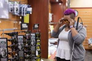 Woman trying on sunglasses in a store.